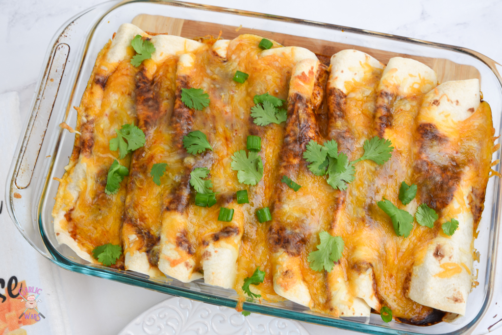 chicken enchiladas in a pan with melted cheese and cilantro