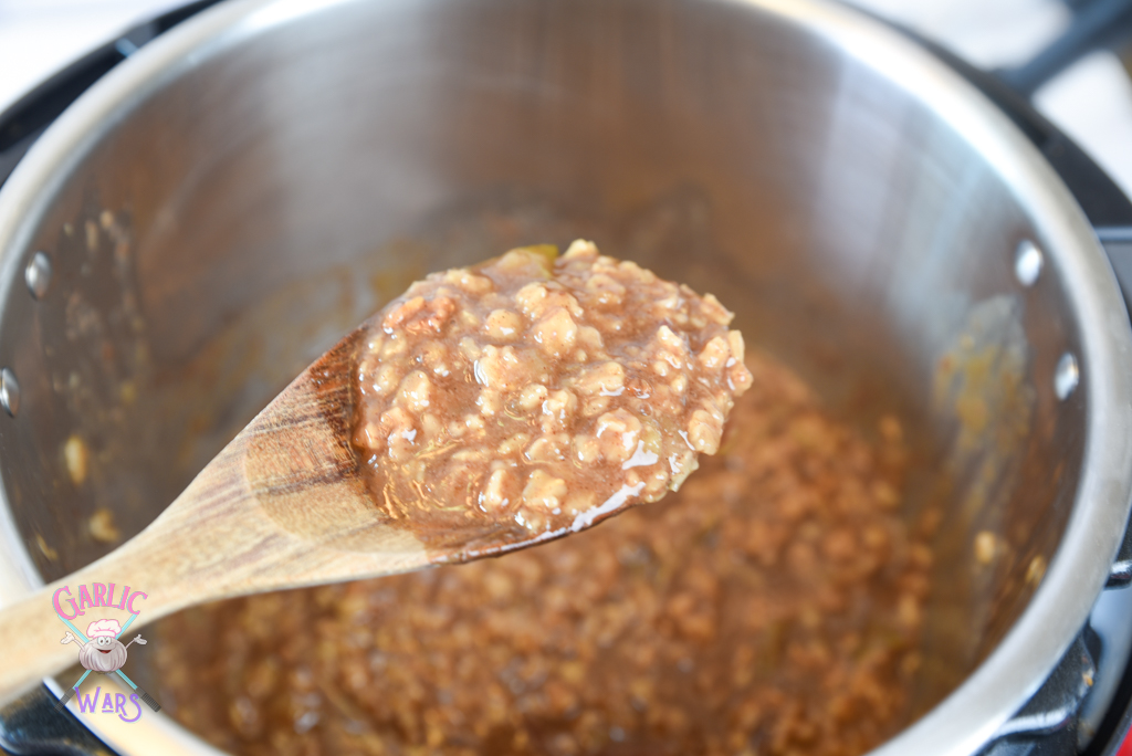apple pie oatmeal in the instant pot, on a large wooden spoon.