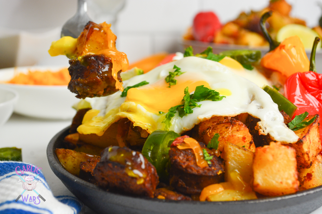 chorizo and potato hash on a  cast iron skillet, with bell peppers, jalapenos, and a fried egg. 