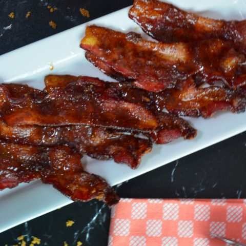 candied bacon with orange checkered towel on black marble counter