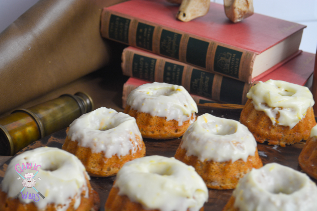 sweetrolls with glaze on wooden cutting board, with old books in background