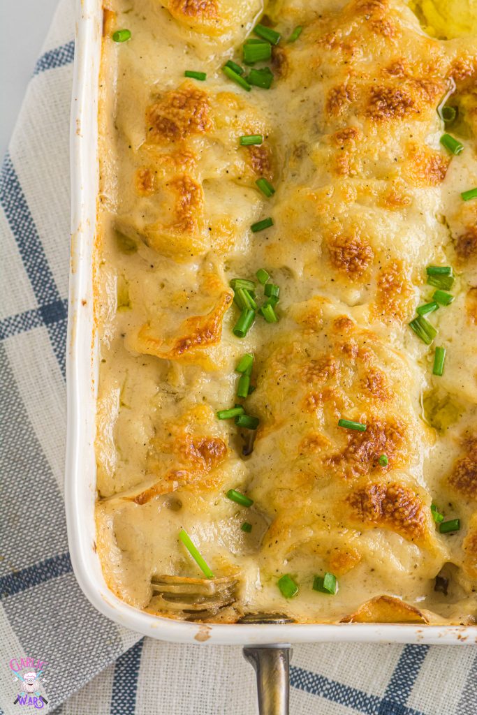 close up of scalloped potatoes in a white casserole pan