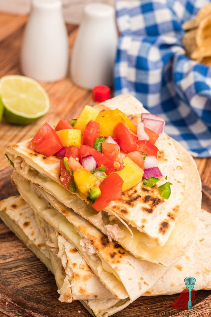 peach salsa on a stack of chicken quesadillas