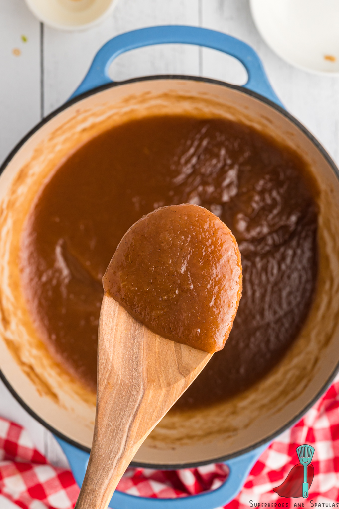 a spoon holding up apple butter