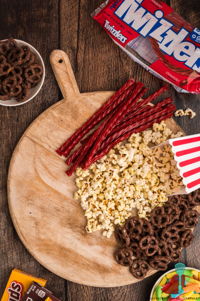 popcorn, twizzlers, and pretzels on a board